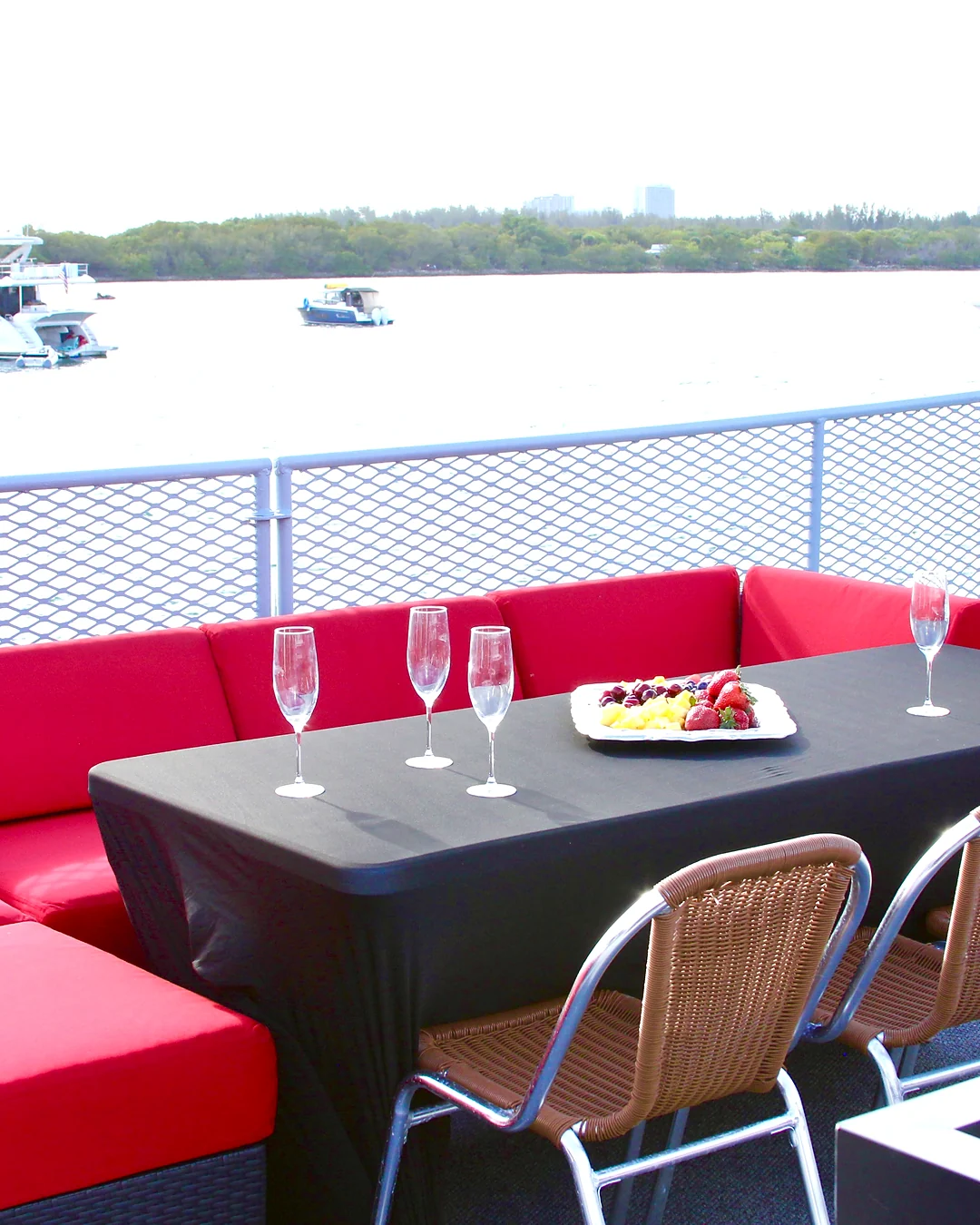 Outdoor table and red lounge aboard Opus Yacht Miami